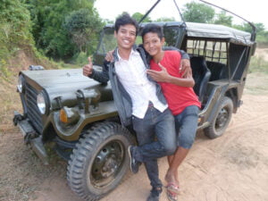 Ratha and Darith pose near a US jeep during a break in production on 'Freedom Deal: The Story of Lucky' proudced by Camerado Media